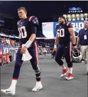  ?? Winslow Townson / Associated Press ?? Patriots quarterbac­k Mac Jones (10) walks off the field with center David Andrews (60) after a 17-16 loss to the Dolphins on Sunday in Foxborough, Mass.