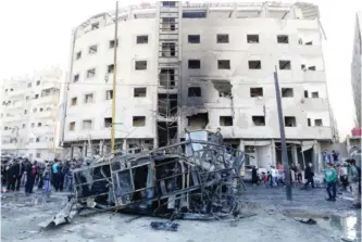  ??  ?? DAMASCUS: Syrian security forces and residents gather at the site of suicide bombings in the area of a revered shrine in the town of Sayyida Zeinab on the outskirts of the capital yesterday. — AFP
DAMASCUS: