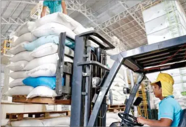 ?? HENG CHIVOAN ?? An employees uses a forklift to stack pallets of rice at a storage and processing plant on the outskirts of Phnom Penh in 2015.