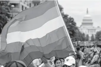  ?? Associated Press file photo ?? A person holds a rainbow flag at a Washington rally backing the LGBTQ community. A bill in the Senate would require states to recognize all marriages that were legal where they were held.