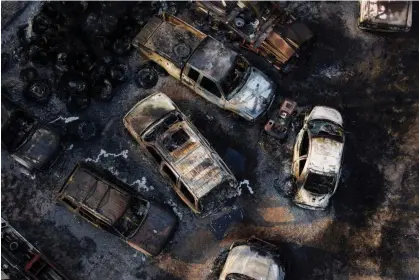  ?? ?? Charred vehicles sit at an auto body shop after the property was burned by the Smokehouse Creekfire in Canadian, Texas, on Wednesday. Photograph: Julio Cortez/AP