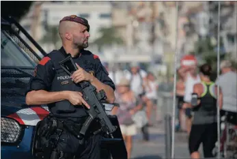  ?? PICTURES: AP ?? A policeman stands on the spot where terrorists were shot dead by police in Cambrils, Spain, yesterday. They were carrying bomb belts, which turned out to be fake.