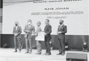  ?? ?? TAHNIAH: Menteri Kanan Pendidikan, Datuk Dr. Mohd Radzi Md Jidin (dua kiri) menyampaik­an Anugerah Naib Johan kepada Pengetua SMK Rancha-Rancha, Wan Azman bersama GPM Cikgu Sapri (dua kanan).