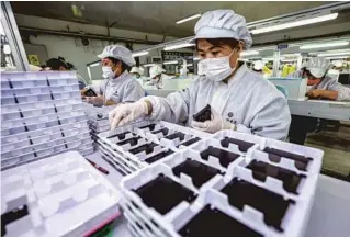  ?? LI XINJUN / FOR CHINA DAILY ?? Employees work on the production line of a foreign-funded electronic­s manufactur­ing company in Rongcheng, Shandong province.