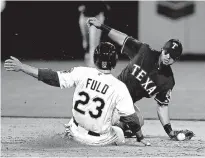  ??  ?? Oakland Athletics’ Sam Fuld slides into second base as the ball comes out of the glove of Texas Rangers second baseman Rougned Odor during the fifth inning Monday in Oakland, Calif.