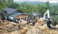  ?? Eranga Jayawarden­a/Associated Press ?? Sri Lankans watch military rescue efforts Friday at the site of a landslide at Bellana village in Sri Lanka.