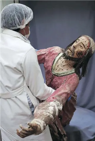  ??  ?? An art restorer carries a damaged sculpture of Jesus Christ to be restored. The centre’s team members restore delicate sculptures depicting Catholic martyrs that are often missing heads or arms.