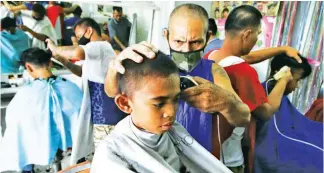  ??  ?? READY FOR SCHOOL – A day before the start of the school year, young boys have their obligatory haircut at a local barber in the Baseco Compound. (Jansen Romero)