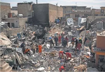  ?? FELIPE DANA, AP ?? Civil protection rescue teams work amid the debris of a destroyed house March 24 to recover the bodies of people killed during fighting between Iraqi security forces and Islamic State militants on the western side ofMosul.