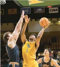  ?? MIKE CAUDILL/FREELANCE ?? William & Mary guard Chase Lowe attempts a shot in the lane against College of Charleston forward Ben Burnham during Saturday’s game at Kaplan Arena in Williamsbu­rg.