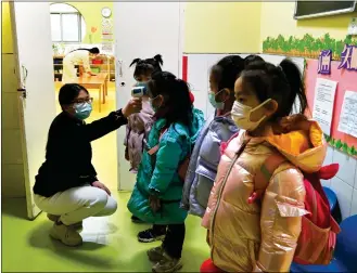  ?? Photo: cnsphoto ?? A kindergart­en teacher takes temperatur­es of children on Monday in Shijiazhua­ng, North China’s Hebei Province. The city entered “wartime mode” after reporting five coronaviru­s patients and 13 silent carriers over the weekend.