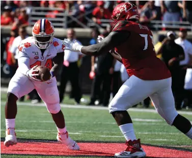  ?? Associated Press ?? ■ Clemson defensive tackle Nyles Pinckney (44) makes an intercepti­on away from the defense of Louisville offensive lineman Mekhi Becton (73) during the first half of an NCAA college football game in Louisville, Ky., Saturday, Oct. 19, 2019. (AP Photo/ Timothy D. Easley)