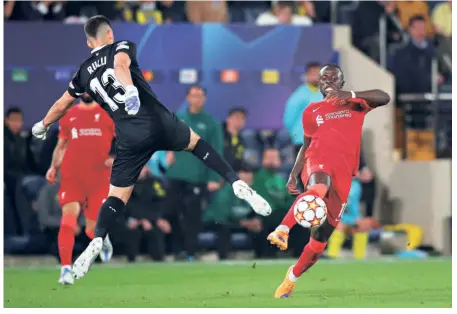  ?? GETTY IMAGES ?? Milestone: Sadio Mane of Liverpool evades a tackle from Geronimo Rulli of Villarreal before scoring the side’s third goal during the UEFA Champions League semifinal against Villarreal at the Estadio de la Ceramica. With the goal, Mane became the highest African goalscorer in the Champions League knockouts (15 goals).