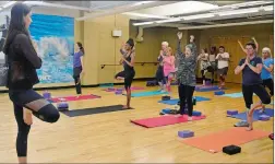  ??  ?? Instructor Maggie Skinner, left, holds a pose as she helps lead a community yoga class on Saturday, Sept. 16, 2017, at Ocean Community YMCA in Westerly. SARAH GORDON/THE DAY