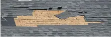  ?? TYLER BROWNBRIDG­E ?? A bare patch is seen after strong winds stripped shingles from a roof in Windsor on Wednesday.