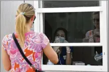  ?? TONY GUTIERREZ / ASSOCIATED PRESS ?? A Parkland Hospital employee behind window, gives verbal instructio­ns to a woman who was self-administer­ing a COVID-19 test at a walk up site in Dallas, Thursday. The walk ups have extended their hours of operation this week, with officials urging anyone who has participat­ed in large gatherings of any sort, to be tested for the coronaviru­s.