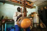  ??  ?? Brother Marie Firmin, 40, plays kora inside the kora making workshop of the Abbey of Keur Moussa.