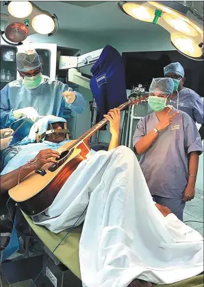  ?? MAHAVEER JAIN HOSPITAL VIA AGENCE FRANCE-PRESSE ?? Musician Abhishek Prasad plays guitar during brain surgery in Bangalore, India, on Thursday.