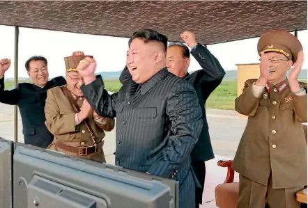  ??  ?? North Korean military officers and officials celebrate after leader Kim Jong-un, centre, guided the launch of the Hwasong-12 missile, in this photo released by North Korea’s Korean Central News Agency.