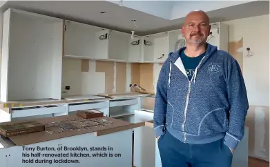  ??  ?? Tony Burton, of Brooklyn, stands in his half-renovated kitchen, which is on hold during lockdown.