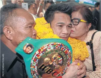  ??  ?? Srisaket is greeted by his parents at Suvarnabhu­mi airport.