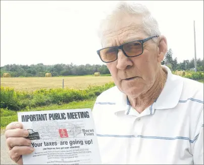  ?? MITCH MACDONALD/THE GUARDIAN ?? John Walsh shows a pamphlet that has been handed out to residents in the Georgetown Fire District of Georgetown Royalty and Burnt Point advertisin­g a public meeting tonight at Rodd’s Brudenell River Resort. Walsh said residents of the unincorpor­ated area have concerns over what amalgamati­on will mean for them.