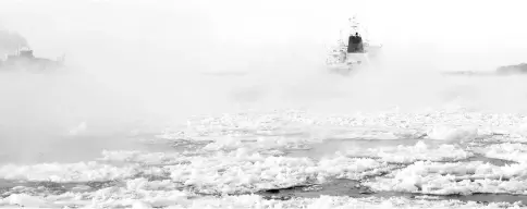  ??  ?? Cargo ships make their way down the ice-covered Saint Lawrence River at the Sorel-Tracy Ferry crossing in Sorel-Tracy, Quebec. A bitter Arctic chill settled across Canada and much of the United States and is expected to last into early 2018,...