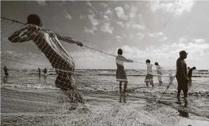  ?? Adriana Loureiro Fernandez / New York Times ?? Fishermen cast a net along the Venezuelan coast, where refineries that once processed oil exports are now rusting hulks.