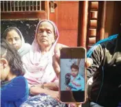  ?? PIC/MPOST ?? Family members showing 27-year-old Ishtiyak Khan’s picture, who was killed in the violence