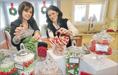  ?? Postmedia News photos ?? AMR Design decorators Michelle Pollock, left, and Brenda Brix create a candy bar using beautiful glass apothecary jars.