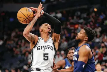  ?? Andy Clayton-king / Associated Press ?? The Timberwolv­es’ Malik Beasley, right, knocks the ball away from Spurs guard Dejounte Murray on Thursday. Murray finished with a season-low seven points and a season-low-matching four assists.