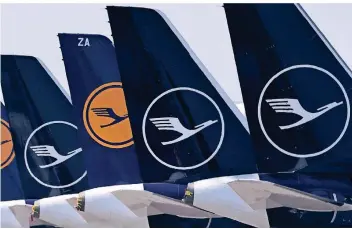  ?? FOTO: AFP ?? Lufthansa-Maschinen auf dem Flughafen München: Dort muss die Fluggesell­schaft, die seit kurzem mit einem neuen blau-weißen Logo fliegt, Rechte abgeben.