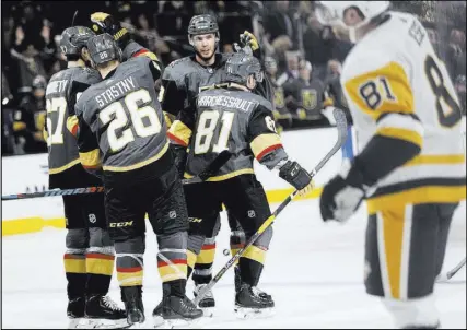  ?? Chase Stevens˜Las Vegas Review-Journal @csstevensp­hoto ?? Golden Knights players celebrate with Jonathan Marchessau­lt after he finished off a hat trick in the third period of Vegas’ 7-3 win over the Penguins on Saturday at T-Mobile Arena.