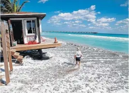  ?? SUSAN STOCKER/STAFF PHOTOGRAPH­ER ?? Waves pound a Dania Beach lifeguard station on Tuesday. The Dania Beach parking lot, which includes access to the Quarterdec­k Restaurant, has been closed for three days.