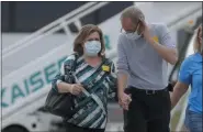  ?? JEFF CHIU - ASSOCIATED PRESS ?? Passengers from the Grand Princess, a cruise ship carrying multiple people who have tested positive for COVID-19, walk on a tarmac Tuesday before boarding a chartered plane in Oakland, Calif.