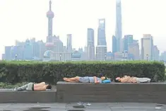  ??  ?? People sleeping on the waterfront bund to keep cool in Shanghai. US corporate acquisitio­ns in China collapsed to their lowest level for 14 years in the first half of this year, as trade tensions between the two countries and uncertaint­y about Chinese government regulation­s took a toll on deal making. — AFP photo