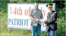  ?? Keith Bryant/The Weekly Vista ?? Economic developmen­t manager Travis Stephens, left, hands a check for $1,000 to Jim Parsons. The funds were awarded by the advertisin­g and promotion commission, Discover Bella Vista, to help put on the Fourth of July parade in the Sugar Creek Center parking lot.