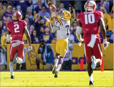  ?? NWA Democrat-Gazette/BEN GOFF ?? LSU wide receiver DJ Chark catches a fourth-quarter touchdown pass as Arkansas cornerback Kamren Curl (2) and linebacker Randy Ramsey trail Saturday at Tiger Stadium in Baton Rouge. LSU won 33-10 to snap Arkansas’ two-game winning streak.