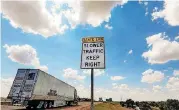  ?? [PHOTO BY CHRIS LANDSBERGE­R, THE OKLAHOMAN] ?? Traffic drives by one of the highway signs that warn drivers to stay out of the left lane near El Reno. A new state law starts in November restrictin­g the left lane for passing only.