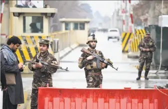  ?? Wakil Kohsar / AFP / Getty Images ?? Soldiers patrol near the site of a suicide bombing that killed at least two people in Kabul. A separate attack by Taliban insurgents killed at least 18 soldiers in western Farah province.