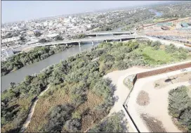  ?? JOHN MOORE / GETTY IMAGES ?? A U.S. Customs and Border Protection helicopter flies over a border fence Tuesday between the United States and Mexico in Hidalgo. The Border Patrol has more than 20,000 agents; 85 percent work along the Mexican border.