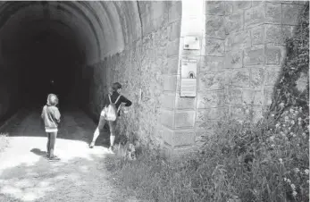  ?? Foto: Javier Arizaleta ?? Dos senderista­s revisan los interrupto­res de la iluminació­n del túnel.
