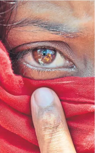  ?? ?? A worker of the closed Swan Garments factory covers her face with a scarf to shelter from the sun as she protests outside the Bangladesh Garment Manufactur­ers and Export Associatio­n office in Dhaka, Bangladesh