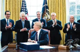  ?? ERIN SCHAFF Getty Images pool ?? From left, Treasury Secretary Steven Mnuchin, Senate Majority Leader Mitch McConnell, R-Ky., House Minority Leader Kevin McCarthy, R-Calif., Vice President Mike Pence, and Rep. Kevin Brady, R-Texas, applaud President Donald Trump on March 27 during a bill-signing ceremony for the $2 trillion CARES Act, which included $350 billion for small businesses.