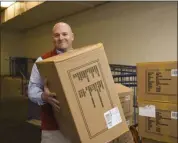  ?? LAUREN A. LITTLE – MEDIANEWS GROUP ?? Hope Rescue Mission executive director Rob Turchi picks up a donation of Heat Holders Socks from Boscov’s East on Tuesday.