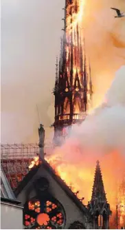  ??  ?? Smoke billows as fire engulfs the spire of the Notre-Dame Cathedral in Paris.