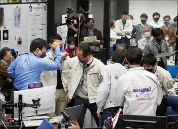  ?? Jaxa via AP ?? Japanese project managers celebrate the successful recovery of a capsule containing samples from an asteroid. The spacecraft Hayabusa2 released the small capsule Saturday and sent it toward Earth. It was recovered in Australia.