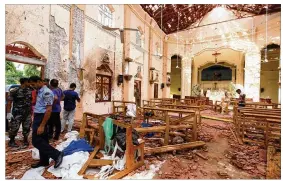  ?? GETTY IMAGES ?? Sri Lankan officials inspect St. Sebastian’s Church in Negombo, north of Colombo, after multiple explosions targeting churches and hotels across Sri Lanka on Sunday in Negombo, Sri Lanka. At least 207 people have been killed and hundreds more injured