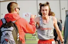  ??  ?? Farmington’s Mason Gansz receives congratula­tions from Farmington coach Greg Pair after winning the 1600 meter race with a time of 5:09.59 during the Blackhawk Relays hosted by Pea Ridge on April 8. Pair coached three sports, boys track and field, girls track and field and baseball, during the spring semester. Farmington recently hired coaches to fill several voids.