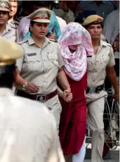  ?? — AP ?? Honeypreet Insan (head covered with scarf) leaves after being produced in a court in Panchkula on Wednesday.